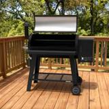 Nexgrill Oakford pellet grill on a wooden deck with the lid open, empty cooking grate and warming rack showing