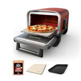 Ninja Woodfire outdoor oven on a garden table, door open, a pizza on the stone pulled forward