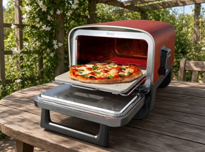 Ninja Woodfire outdoor oven on a wooden garden table, door open with a pizza on the stone