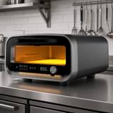 Ooni Volt 2 electric pizza oven on a stainless kitchen bench, interior lit and display showing 850