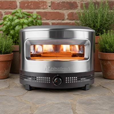 Solo Stove Pi Prime in stainless steel on a stone patio, flame lit inside