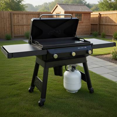 Traeger Flatrock griddle on grass with the lid raised, flat steel cooktop and both fold-out side shelves open