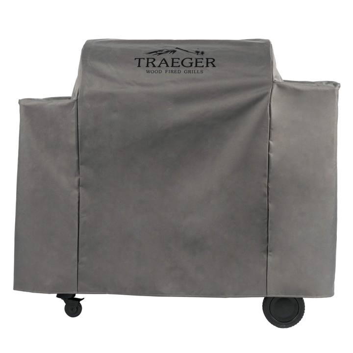 Gray Traeger full-length cover with a black logo over an Ironwood 885 pellet grill, wheels showing below the hem