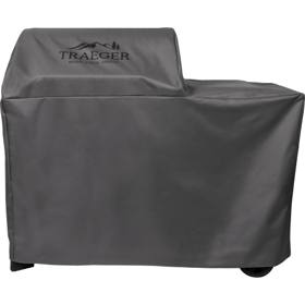 Gray Traeger full-length cover on a Woodridge pellet grill, mountain logo on the hood, wheels showing under the hem