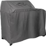 Three-quarter view of the gray Traeger Woodridge cover from the hood end, the fabric dropping to just above the wheels