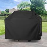 Black Unicook cover fitted over a cart grill on a stone patio, lawn, trees and iron fence behind
