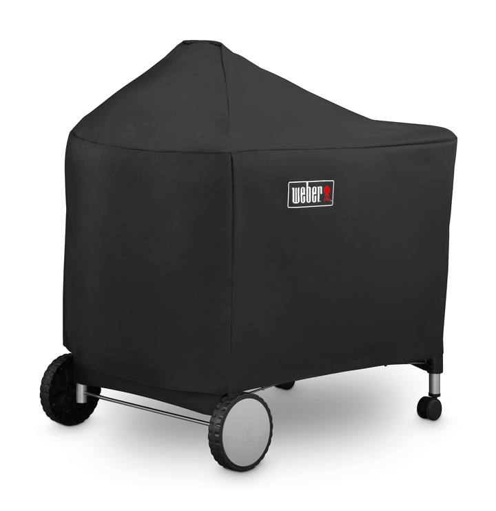 Black Weber cover over a Performer kettle and its full-width cart table, wheels and casters showing below the hem