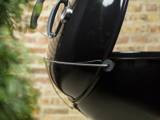 Side of the black Master-Touch bowl showing the wire Tuck-Away lid holder fixed to the bowl rim