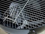 Close-up of the plated-steel cooking grate seated in the Weber kettle bowl, black enamel rim along the edge