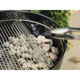Hinged section of the plated-steel grate lifted while tongs add a briquette to the lit coals below