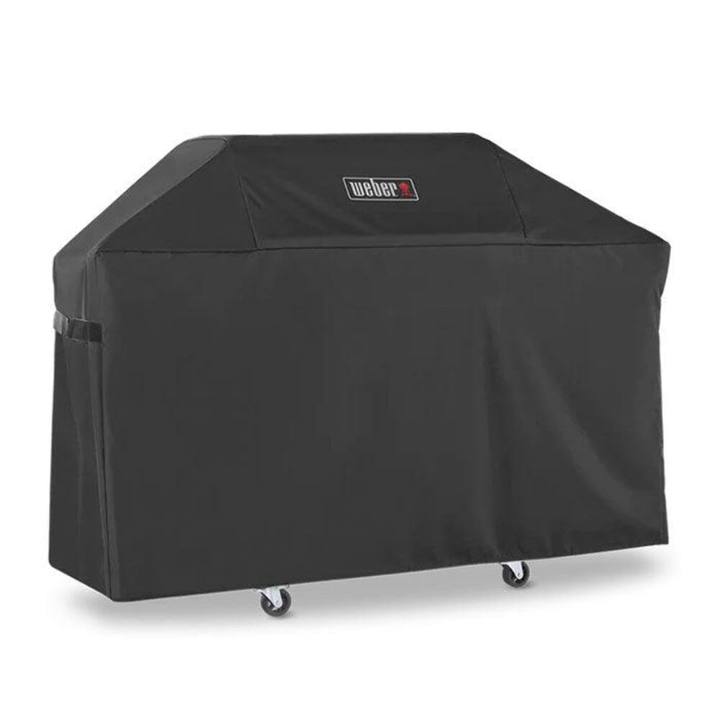 Black Weber Premium Grill Cover over a three-burner Genesis cart, side strap visible, casters showing below the hem