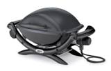 Weber Q 1400 electric grill in dark grey with its lid closed, nylon frame legs and black power cord coiled beside it
