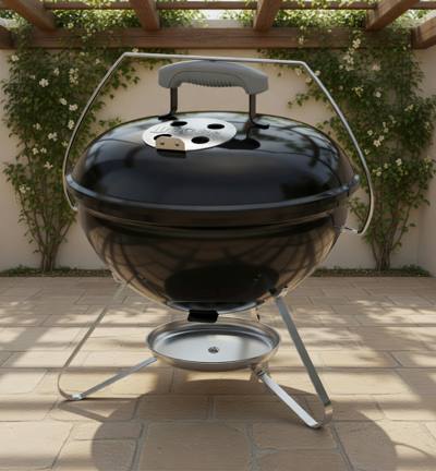 Black Weber Smokey Joe 14 kettle on a patio, lid on, chrome bail handle raised, silver ash catcher below the tripod legs
