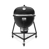 Weber Summit Kamado E6 in black, lid closed, on its three-caster tripod stand with a wire bottom rack