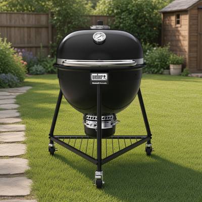 Weber Summit Kamado E6 in black, lid closed, on its three-caster tripod stand with a wire bottom rack