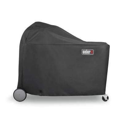 Black Weber 7174 cover over a Summit Kamado grill center, domed at one end, wheel and caster showing below