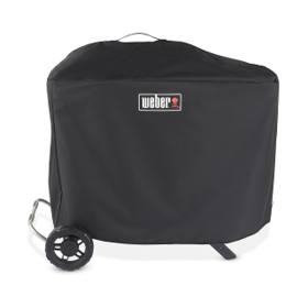 Black Weber Traveler Premium Grill Cover over a standing Traveler, top loop handle, one wheel and a leg showing below